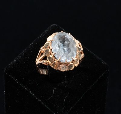 a close up of a gold ring with a blue topaz stone