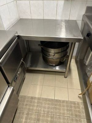 une cuisine en inox avec une grande casserole posée sur le plan de travail