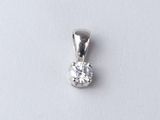 a close up of a diamond pendant on a white surface
