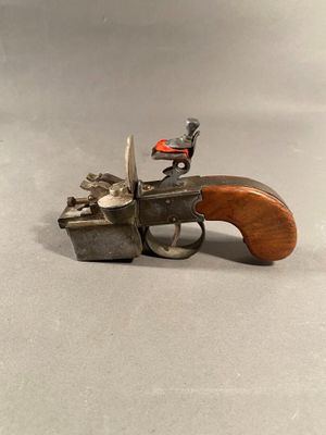 a small toy gun with a wooden handle on a table