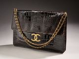 a close up of a black purse with a gold chain