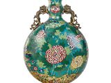 un vase vert orné de fleurs sur fond blanc