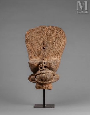 an old wooden mask on a stand with a gray background