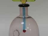 a pink glass vase with a green triangle on top of it