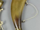 pair of antique brass horns with rope on them on a gray surface