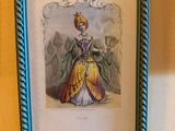 an old picture of a lady in a yellow dress is hanging on a wall