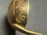 a close up of a gold spoon on a table