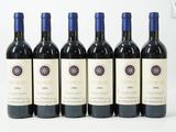 six bouteilles de vin sont alignées sur une surface blanche