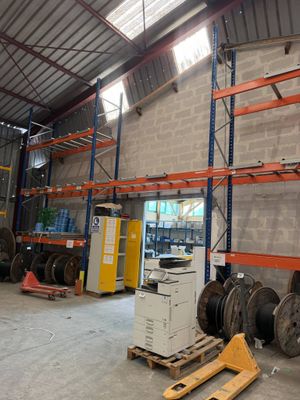 a large warehouse with a lot of pallets and a lot of wires