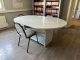 a table and chairs in a room with bookshelves