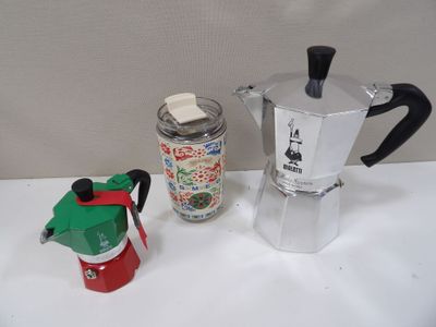 une cafetière et une canette de soda posées sur une table