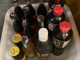 many bottles of soda sitting on a tray on the floor