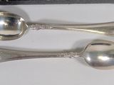 two spoons that are sitting on a table