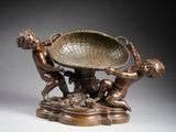 an image of a bronze sculpture of a boy and a boy playing with a bowl