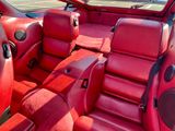 l'intérieur d'une voiture avec des sièges en cuir rouge et une moquette rouge