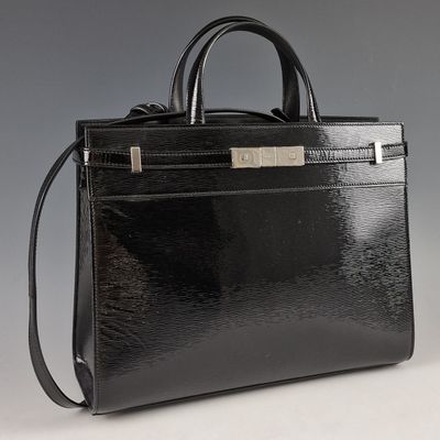 sac à main en cuir noir avec des finitions argentées sur fond gris