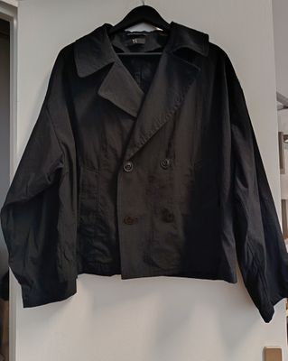black jacket hanging on a white wall in a room