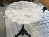une table en marbre blanc avec un piètement en métal noir