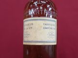 an old bottle of whiskey sitting on a red surface