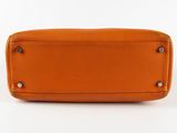 a close up of an orange purse on a white background