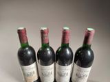 three bottles of red wine are lined up on a table