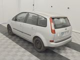 a small white car parked in a room with a checkered floor
