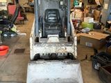 a small bulldozer that is sitting in a garage