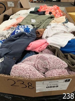 a cardboard box full of clothes on display in a store