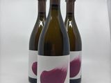 trois bouteilles de vin sont alignées sur une surface blanche