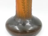 a brown vase with a design on it on a white surface