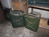 two green jerry cans sitting next to each other on the floor