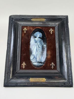 une vieille photo d'une femme en robe bleue, dans un cadre noir