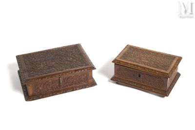 two wooden boxes with carvings on them sitting next to each other