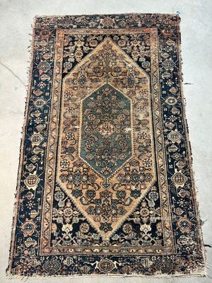 an old rug is laying on the floor in the middle of a room