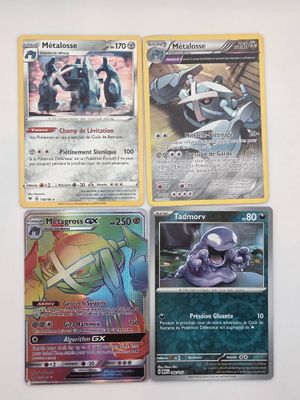 quatre cartes Pokémon différentes posées sur une table blanche