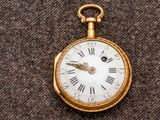 une montre de poche en or avec des chiffres romains