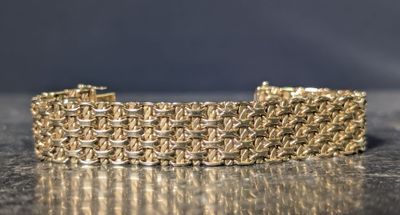 gros plan d'un bracelet en chaîne en or sur une table