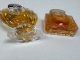 two bottles of perfume sitting next to each other on a table