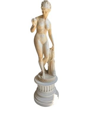 marble statue of a woman holding a dog on a pedestal