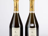 deux bouteilles de champagne posées l'une à côté de l'autre sur une table