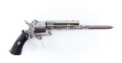 gros plan d'un revolver avec une poignée en bois sur une surface blanche