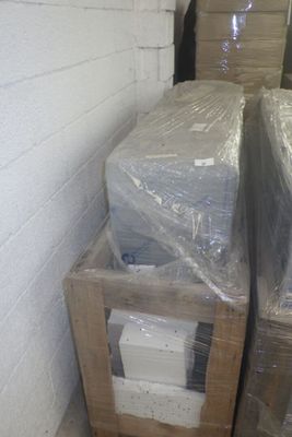 deux cartons contenant du matériel informatique, emballés dans du plastique, posés par terre