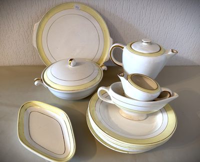 un service de table blanc et doré posé sur une table