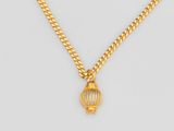 un collier en or avec un pendentif en forme de cage à oiseaux au bout d'une chaîne