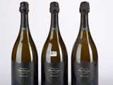 trois bouteilles de champagne posées côte à côte sur une table