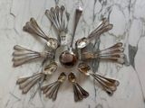 a clock made out of spoons and forks on a marble table