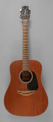une guitare acoustique posée sur un support en bois