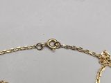 a close up of a gold chain bracelet with a heart on it
