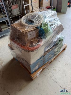 une grande pile de livres posée sur une palette dans un entrepôt