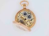 a close up of a pocket watch on a white surface
